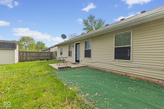 back of house featuring a storage shed, an outdoor structure, a yard, a patio, and fence private yard