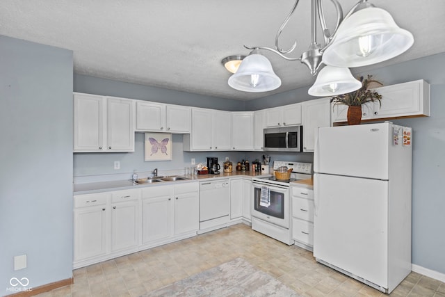 kitchen featuring white cabinetry, white appliances, light countertops, and a sink