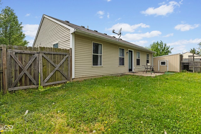 back of property featuring a lawn, a patio, fence, and a gate