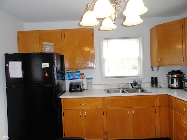 3426 Ireland Dr, Indianapolis, IN 46235 - kitchen featuring light countertops, freestanding refrigerator, brown cabinets, and a sink