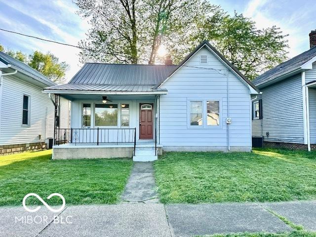 1045 13th St, Tell City, IN 47586 - bungalow with a porch, a front lawn, and metal roof