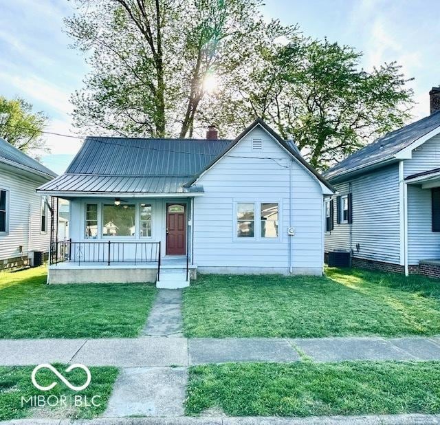 1045 13th St, Tell City, IN 47586 - bungalow-style house with covered porch, a chimney, a front lawn, metal roof, and cooling unit