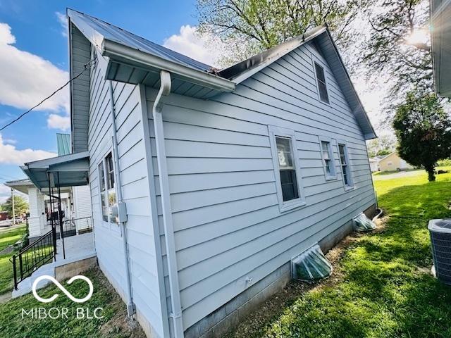 1045 13th St, Tell City, IN 47586 - view of side of home featuring a lawn and central AC unit