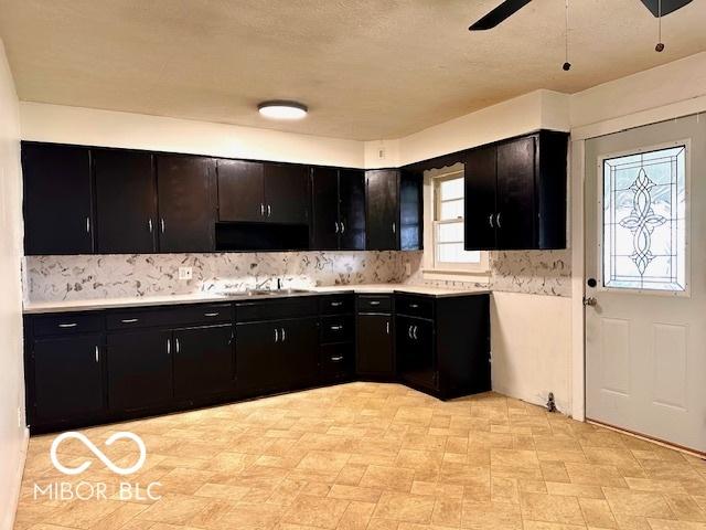 1045 13th St, Tell City, IN 47586 - kitchen with dark cabinets, backsplash, light countertops, and a ceiling fan