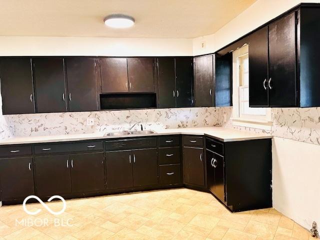 1045 13th St, Tell City, IN 47586 - kitchen featuring a sink, tasteful backsplash, and light countertops