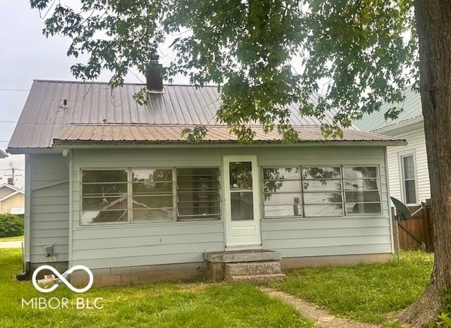 1045 13th St, Tell City, IN 47586 - rear view of property with entry steps, a chimney, a yard, and metal roof