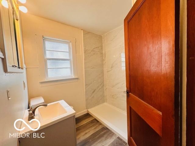 1045 13th St, Tell City, IN 47586 - bathroom with vanity, a tile shower, and wood finished floors