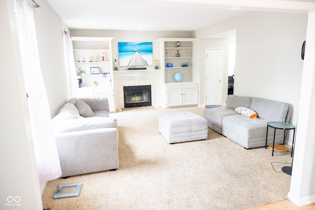 living room with a tiled fireplace and carpet floors