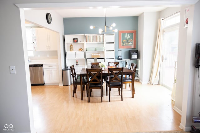 dining room with baseboards, light wood finished floors, and a chandelier