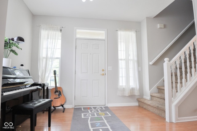 foyer with stairway, light wood-style flooring, and a healthy amount of sunlight