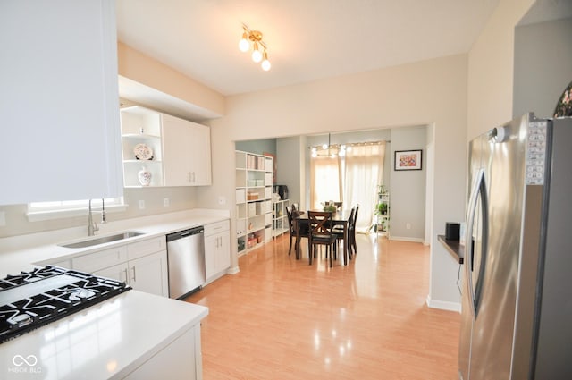 kitchen with open shelves, light countertops, white cabinets, a sink, and stainless steel appliances