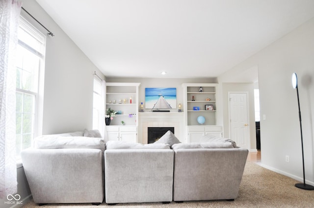 living room with baseboards, carpet flooring, a wealth of natural light, and a fireplace