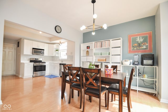 dining space with a chandelier, light wood-style flooring, and visible vents
