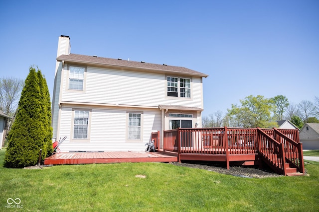 back of house with a chimney, a yard, and a deck