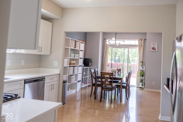 9718 Jupiter Pass, Carmel, IN 46032 - kitchen featuring appliances with stainless steel finishes, a chandelier, white cabinets, and light wood-style flooring