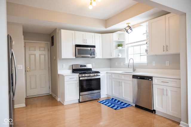 9718 Jupiter Pass, Carmel, IN 46032 - kitchen with appliances with stainless steel finishes, a sink, white cabinets, light wood-style flooring, and open shelves