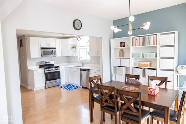 9718 Jupiter Pass, Carmel, IN 46032 - kitchen featuring stainless steel appliances, open shelves, white cabinetry, a sink, and light countertops