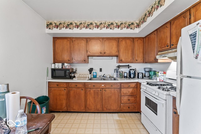 3200 Raible Ave, Anderson, IN 46011 - kitchen featuring a sink, brown cabinetry, white appliances, under cabinet range hood, and light countertops