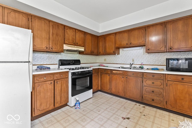 3200 Raible Ave, Anderson, IN 46011 - kitchen featuring a sink, freestanding refrigerator, gas range oven, under cabinet range hood, and black microwave