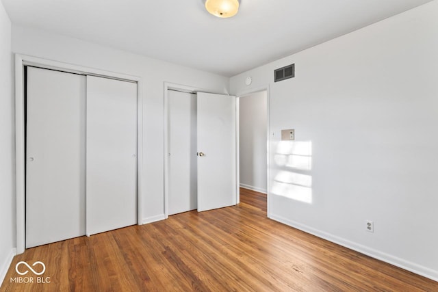 3200 Raible Ave, Anderson, IN 46011 - unfurnished bedroom with two closets, visible vents, wood finished floors, and baseboards