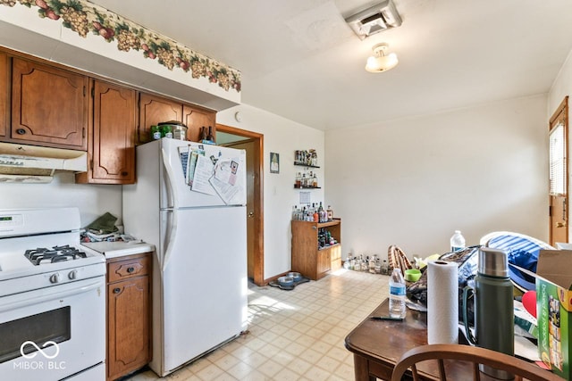 3200 Raible Ave, Anderson, IN 46011 - kitchen featuring light floors, visible vents, white appliances, under cabinet range hood, and light countertops