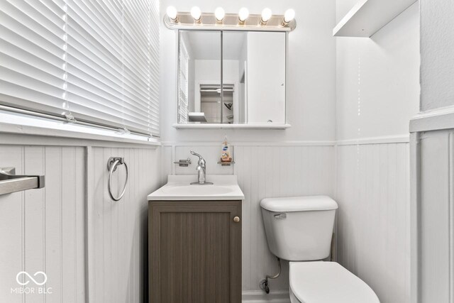 3200 Raible Ave, Anderson, IN 46011 - half bathroom with vanity, toilet, and a wainscoted wall