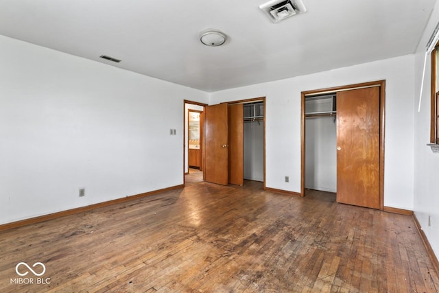 3200 Raible Ave, Anderson, IN 46011 - unfurnished bedroom featuring baseboards, visible vents, two closets, and hardwood / wood-style flooring