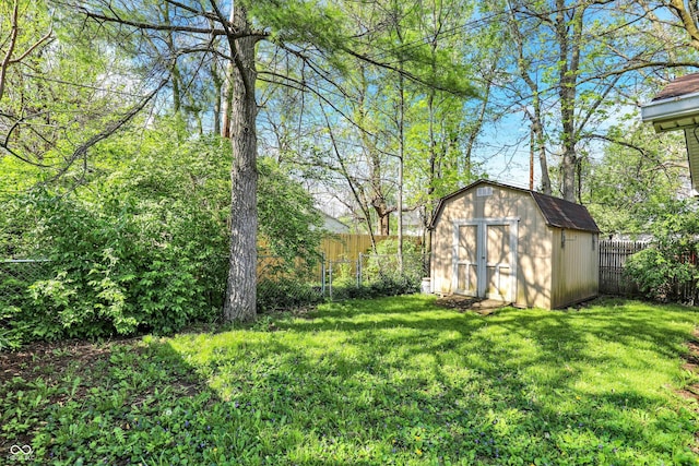 view of yard featuring an outbuilding, a fenced backyard, and a storage unit