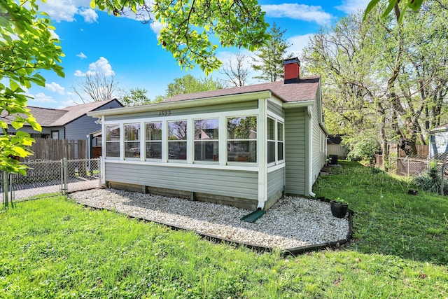 rear view of house with a shingled roof, fence, a yard, and a chimney
