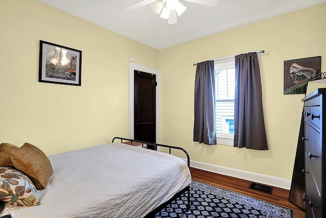 bedroom featuring wood finished floors, baseboards, and a ceiling fan