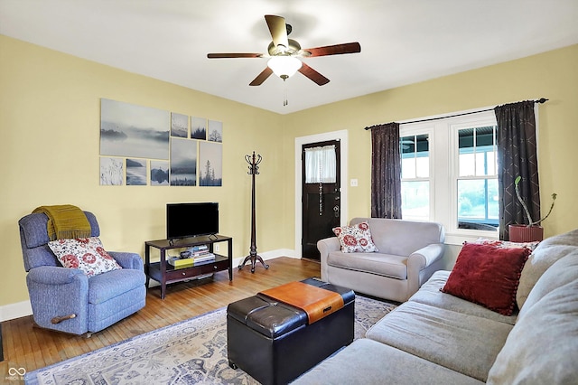 living room with wood finished floors, a ceiling fan, and baseboards