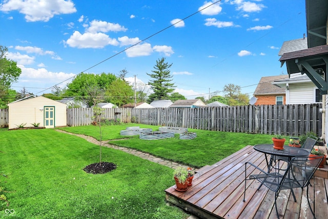view of yard featuring a wooden deck, an outbuilding, a storage shed, and outdoor dining space