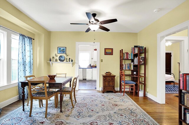 dining space with ceiling fan, wood finished floors, and baseboards