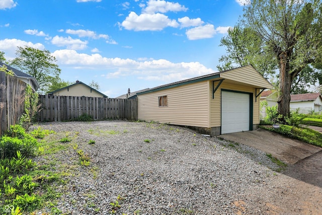 detached garage with fence and driveway