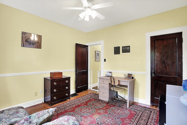office space featuring a ceiling fan, wood finished floors, and baseboards