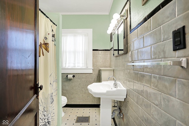 bathroom featuring toilet, tile walls, curtained shower, and ornamental molding