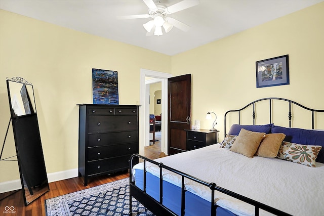 bedroom featuring dark wood-type flooring, baseboards, arched walkways, and ceiling fan