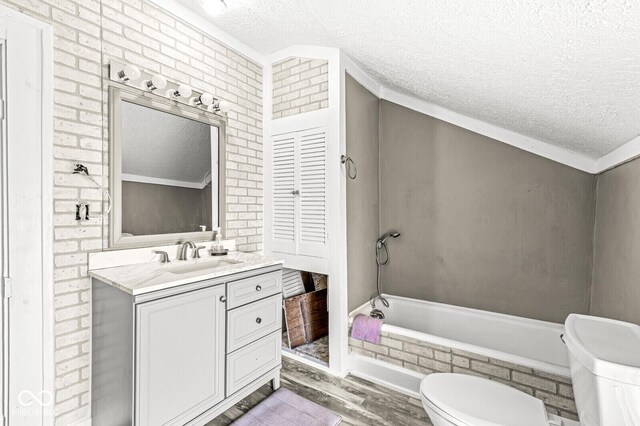 315 W High St, Pendleton, IN 46064 - full bathroom featuring a textured ceiling, toilet, wood finished floors, a relaxing tiled tub, and vanity