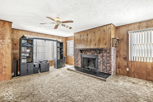 315 W High St, Pendleton, IN 46064 - unfurnished living room featuring wood walls, carpet, a ceiling fan, a fireplace, and a textured ceiling