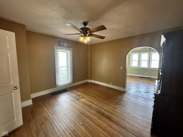 315 W High St, Pendleton, IN 46064 - empty room featuring wood-type flooring, arched walkways, baseboards, ceiling fan, and a textured ceiling