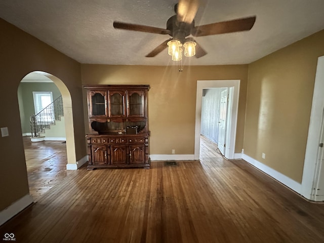 315 W High St, Pendleton, IN 46064 - unfurnished living room featuring a ceiling fan, arched walkways, baseboards, and dark wood finished floors