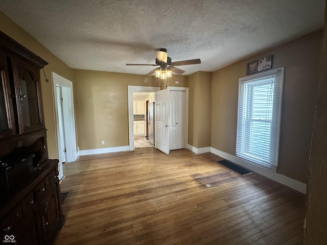 315 W High St, Pendleton, IN 46064 - unfurnished bedroom featuring baseboards, hardwood / wood-style flooring, a textured ceiling, ceiling fan, and a closet