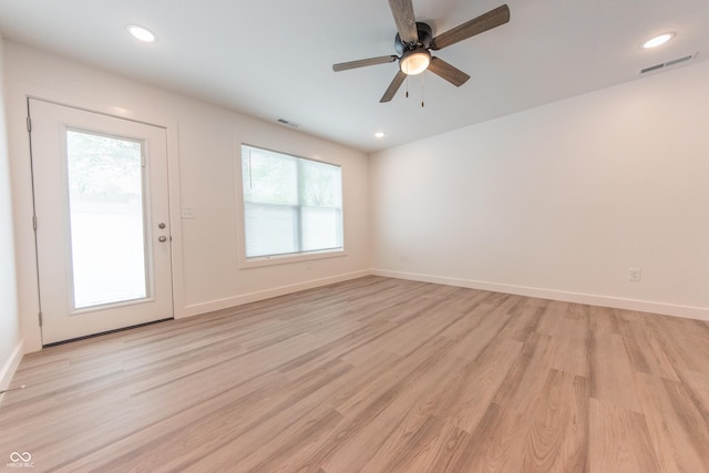 unfurnished living room featuring a healthy amount of sunlight, light wood finished floors, and visible vents