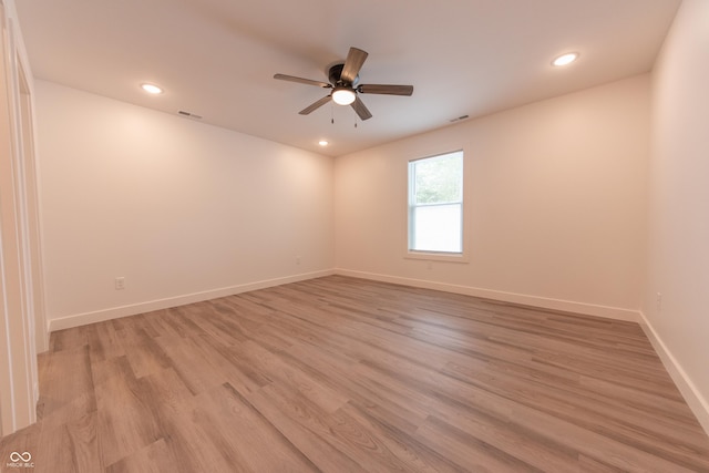 empty room with a ceiling fan, baseboards, light wood-type flooring, and visible vents