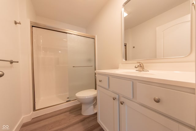 full bathroom featuring vanity, toilet, wood finished floors, and a shower stall