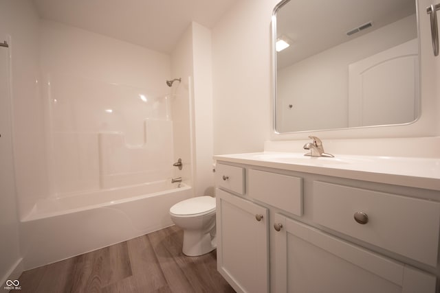 bathroom with toilet, visible vents, vanity, shower / washtub combination, and wood finished floors