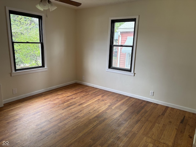 spare room featuring baseboards, a ceiling fan, and hardwood / wood-style floors