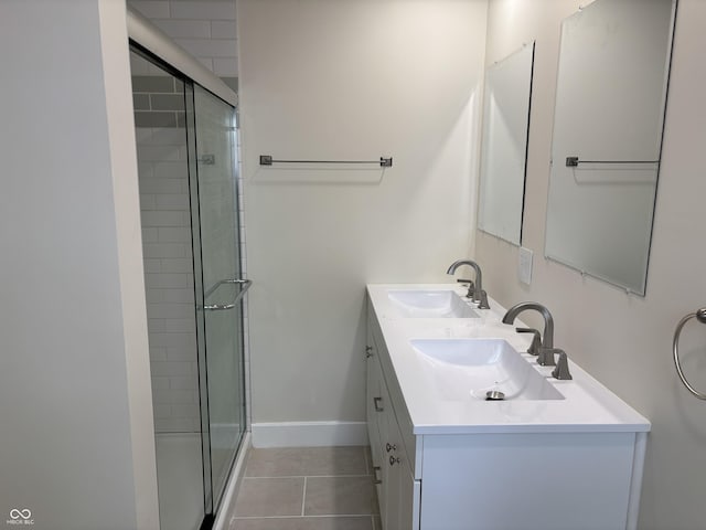 bathroom with a sink, baseboards, tile patterned flooring, and a shower stall