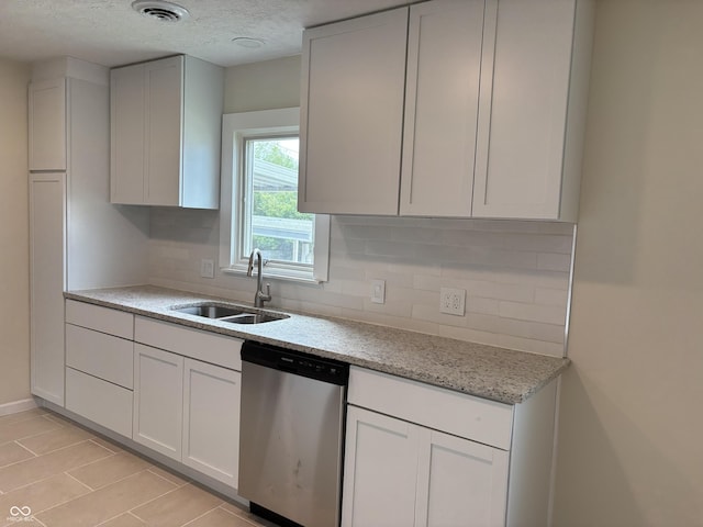 kitchen featuring a textured ceiling, visible vents, tasteful backsplash, stainless steel dishwasher, and a sink