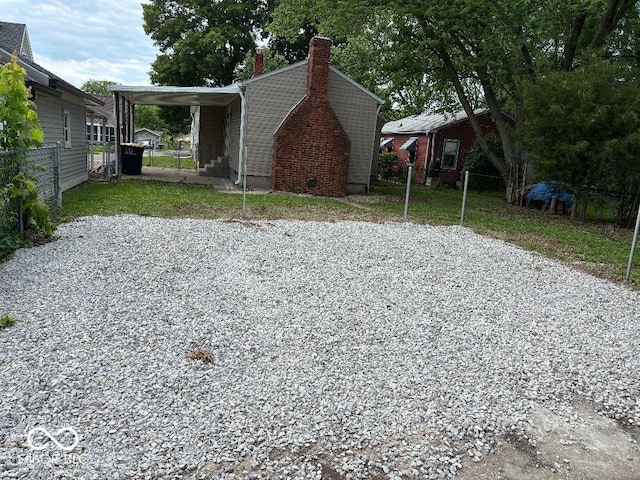 357 N 18th Ave, Beech Grove, IN 46107 - view of side of property with a chimney, a carport, and driveway